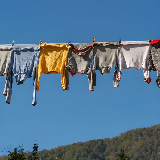 PVC-coated clothesline with clothespins holding assorted laundry on outdoor line