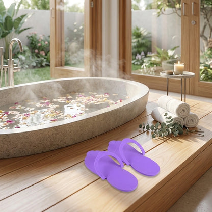Purple flip-flops and rolled towels with foot spa bowl and flower petals
