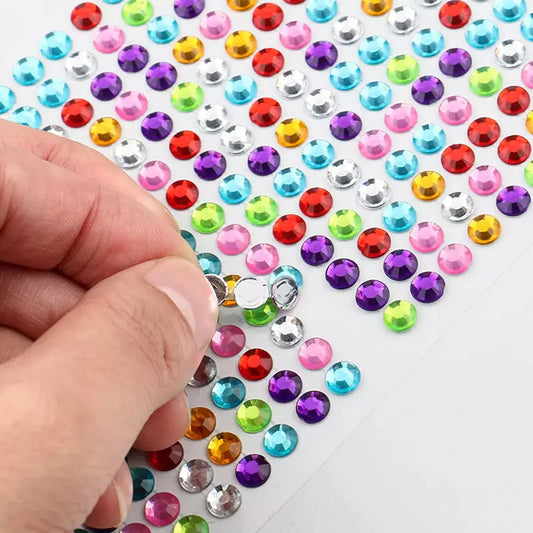 Crystal sticker sheet with multicolor round crystal gems; hand placing one