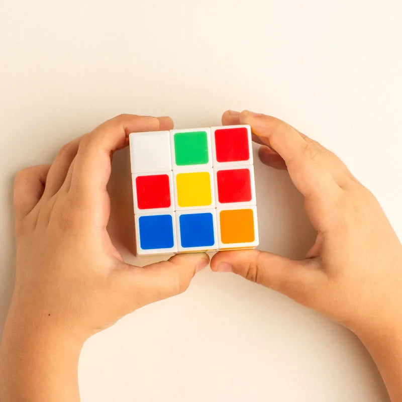 3x3x3 puzzle cube with multicolor square faces held in hands