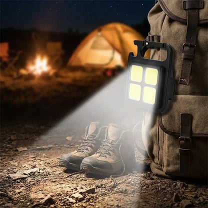 Mini keychain light with 4 LEDs clipped to a backpack
