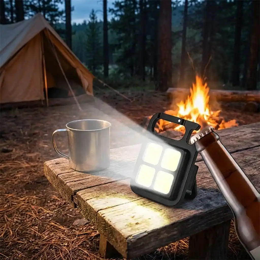 4-LED mini keychain light on a wooden table, square panel glow