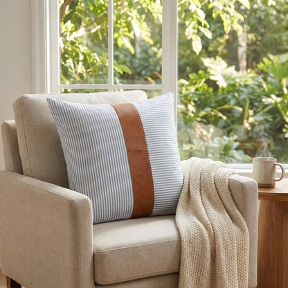 Leather and cotton pillow cover with vertical striped fabric and tan leather trim