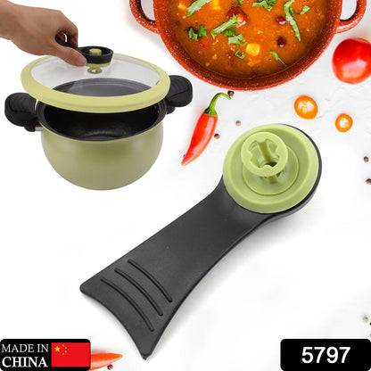 Black cooking pot lid handle with green central knob and valve assembly