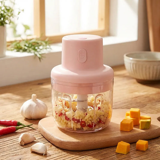 Pink mini garlic chopper with transparent bowl and chopping lid, visible garlic pieces