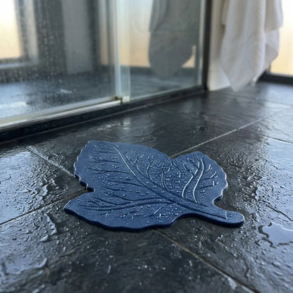 Dark blue leaf-shaped anti-slip baby bath mat with textured grip