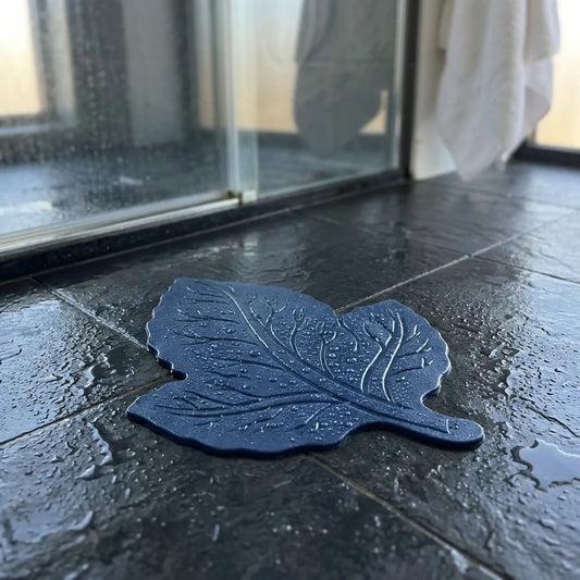 Dark blue leaf-shaped anti-slip baby bath mat with textured grip