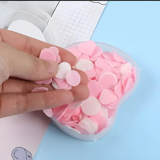 Soft paper soap sheets in pink, round and layered, held in a hand