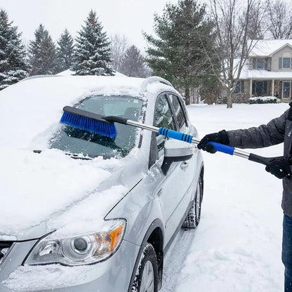 Car ice scraper with blue brush removing snow from front windshield