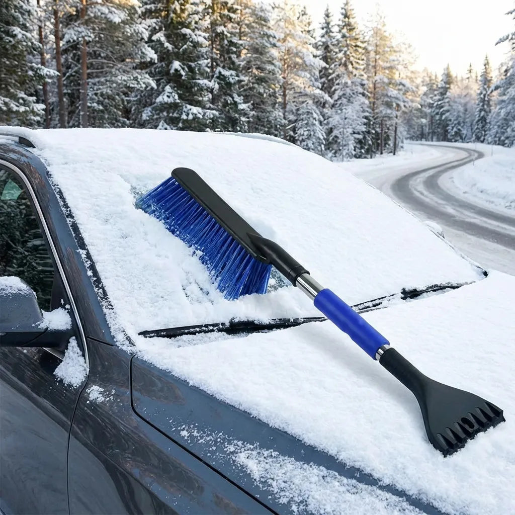 Car ice scraper with blue bristle brush on snow-covered hood