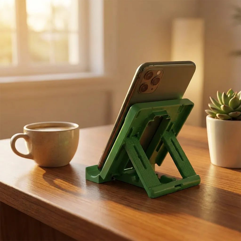 Green mobile stand holding a phone upright beside a coffee cup