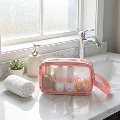 Pink cosmetic wash bag with clear front panel, zipper closure, WASHBAG logo