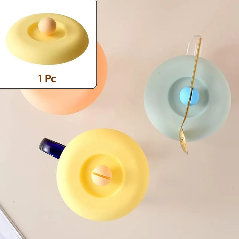 Silicone mug lid in yellow with center drinking hole and raised tab