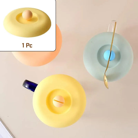Silicone mug lid in yellow with center drinking hole and raised tab