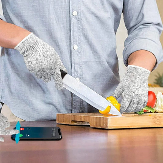 Cut-resistant safety gloves in light gray knit, held while cutting with a utility knife