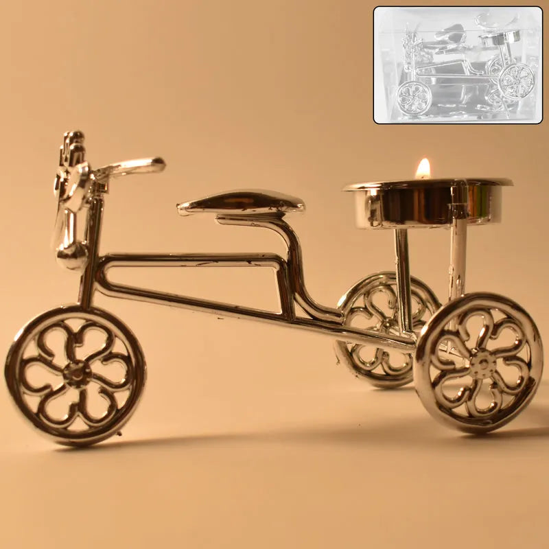 Metal bicycle tealight holder with four-spoke wheels and lit candle