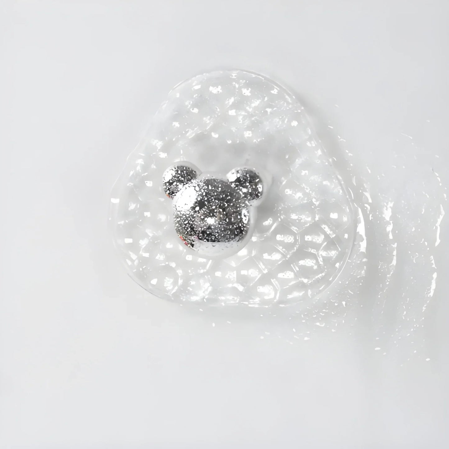 Adhesive hook with clear round backing and silver hook head