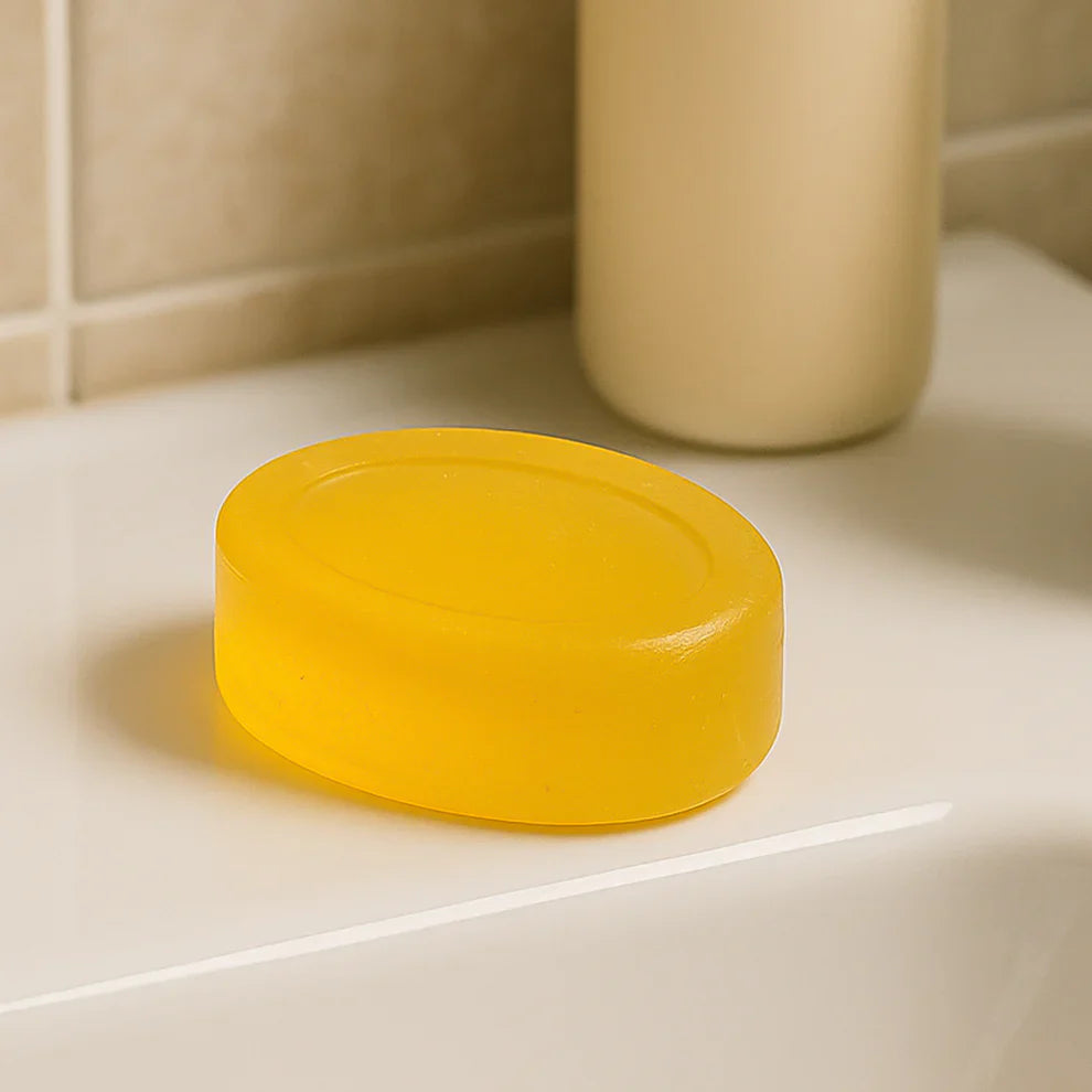 Yellow round bar soap on a bathroom tile surface