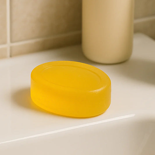 Yellow round bar soap on a bathroom tile surface