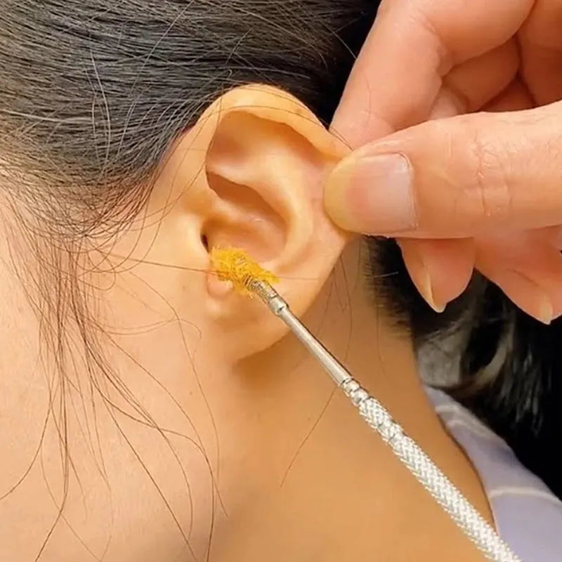 Ear wax removal tool with metal wand applying tip to ear