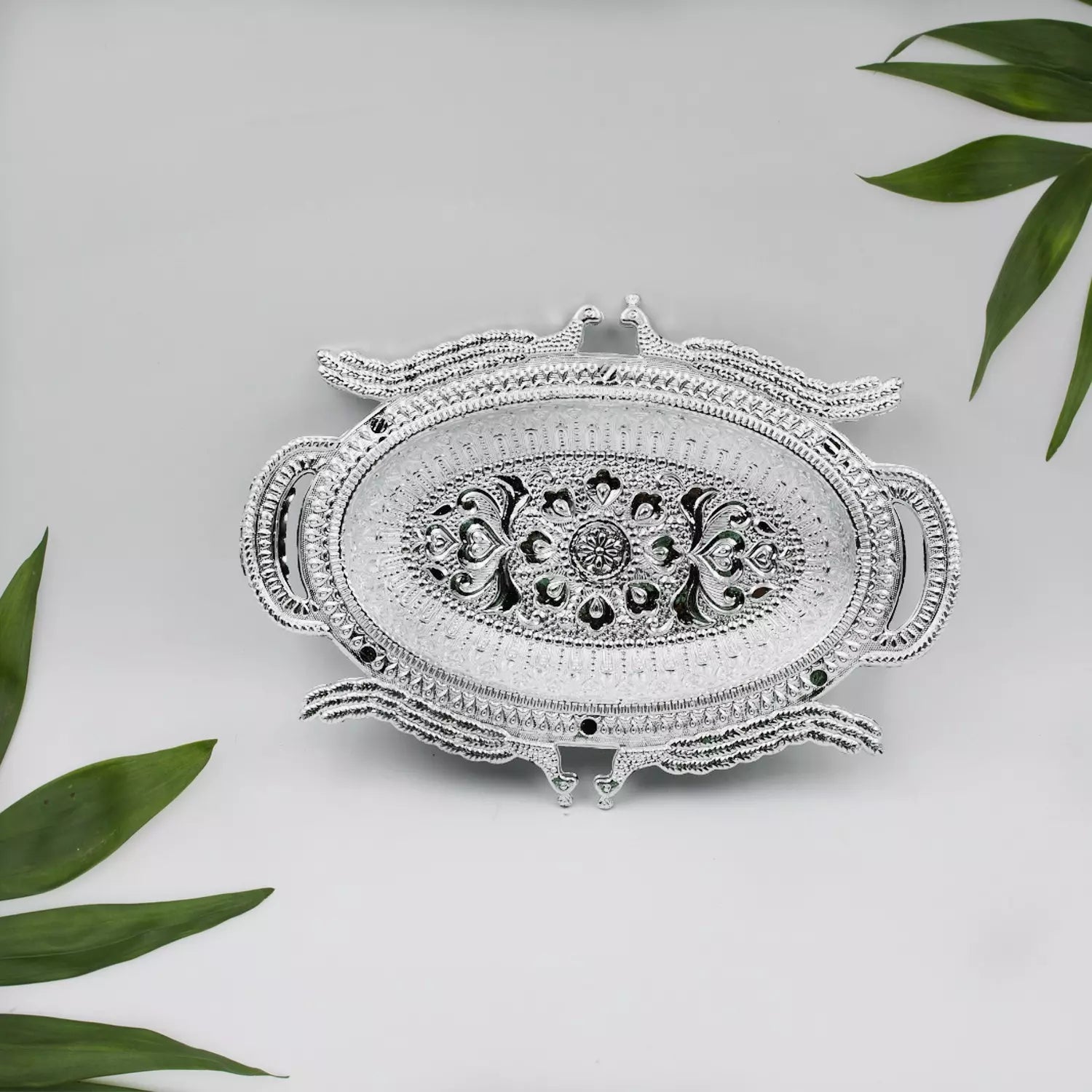 Ornate silver-colored serving tray with filigree border and central floral motif.