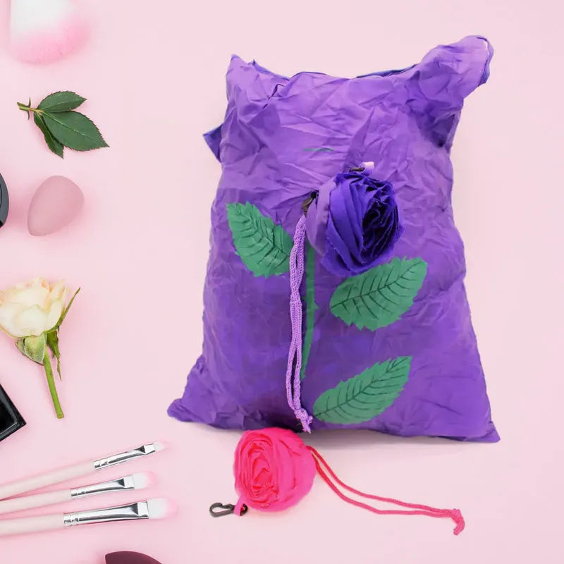 Foldable rose-shaped bag, purple with pink flower and leaf details, drawstring pouch.