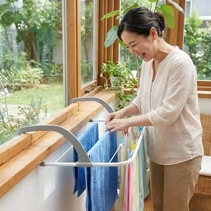 Folding clothes drying rack with clips, displaying blue and white towels on a balcony