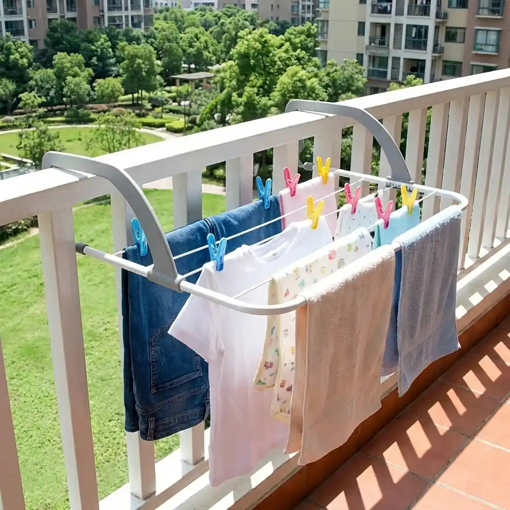 Folding clothes drying rack with clothespins, drying folded garments on a balcony rail