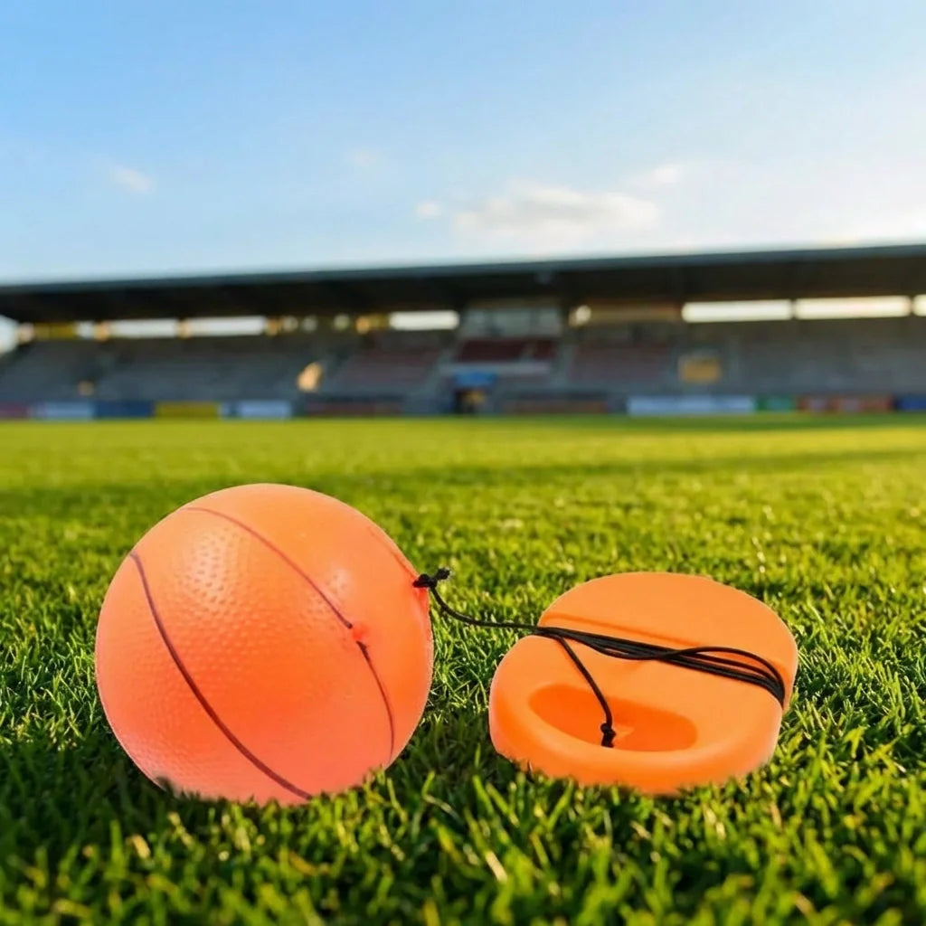 Football rebound ball set with string, orange ball and orange launcher base on grass