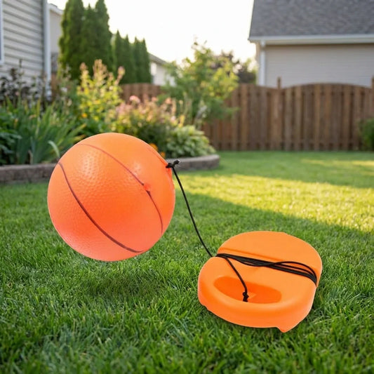 Football rebound ball set with string, orange ball and orange launcher base on grass