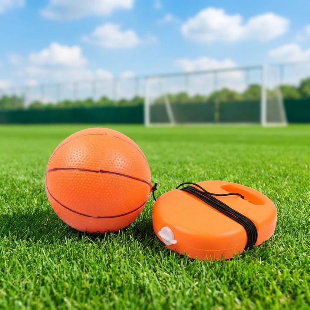 Football rebound ball set with string, orange ball and orange oval launcher base on grass