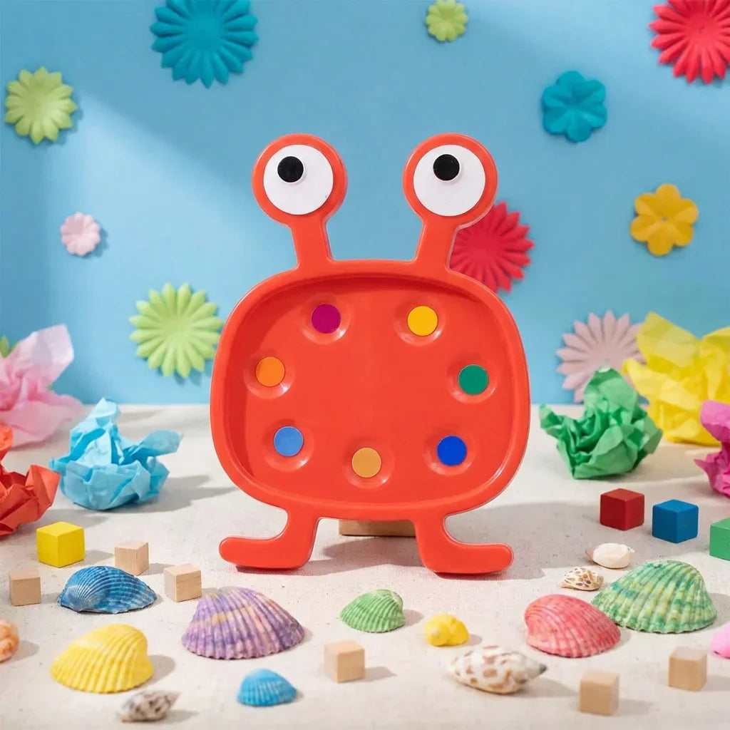 Orange monster plastic toy set with two round eyes and peg holes, plus small shells and blocks
