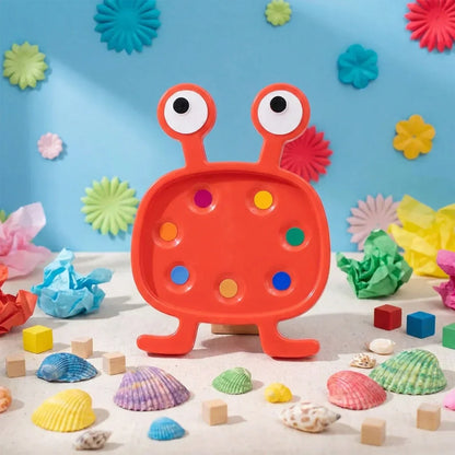 Orange monster plastic toy set with two round eyes and peg holes, plus small shells and blocks