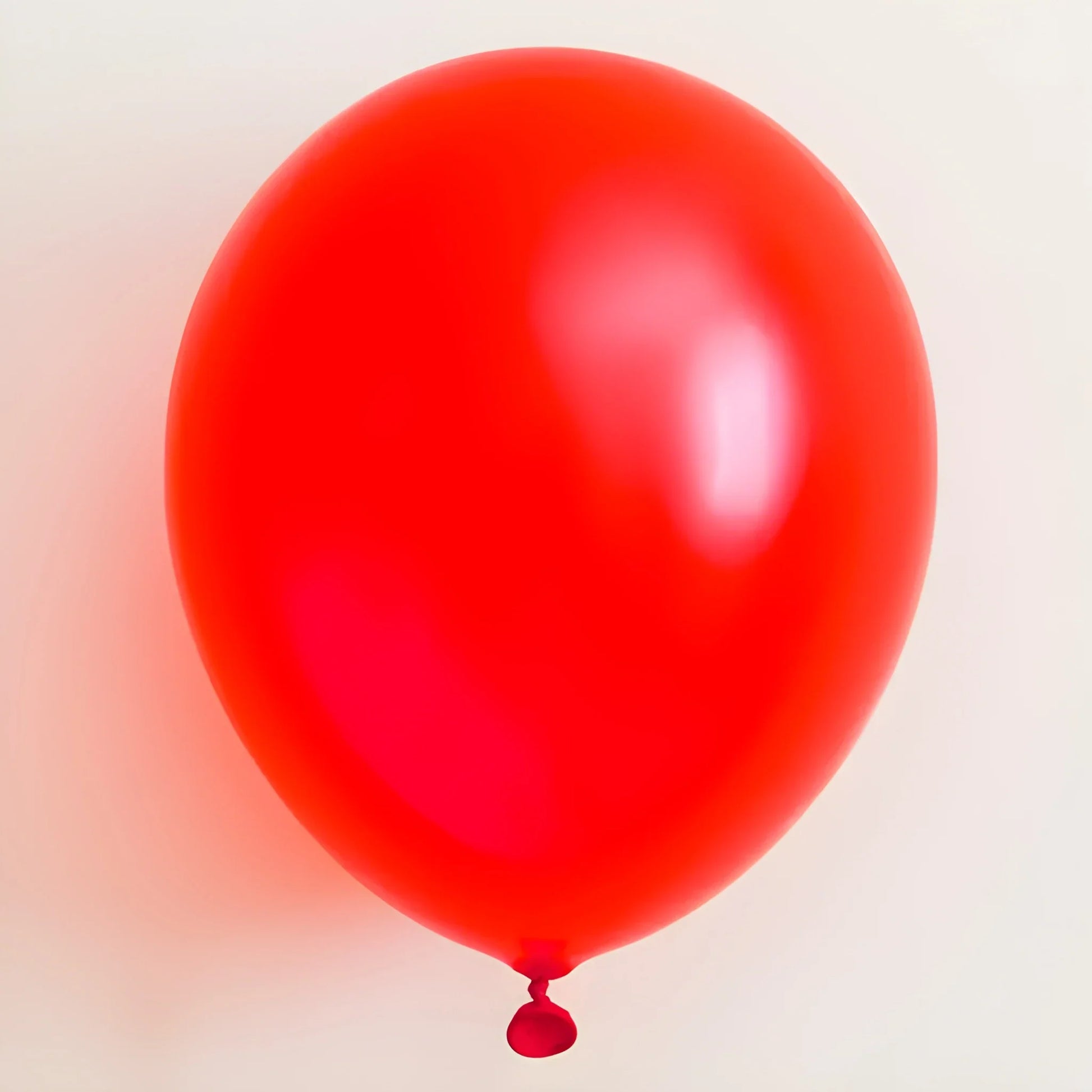 Giant party balloon in red, glossy latex sphere with small tied neck