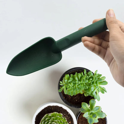 Green heavy-duty garden trowel with curved blade and handle, held in hand
