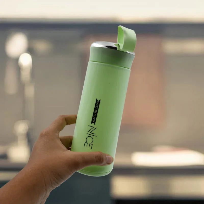 Leakproof glass water bottle with green lid, held in hand