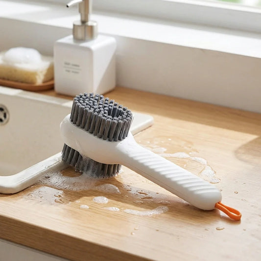 Dish scrubbing brush with dark bristles and orange handle, with soap dispenser bottle
