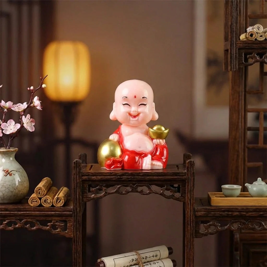Solar-powered Buddha statue on tabletop stand, red robe with gold bowl details