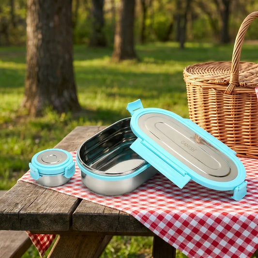 Stainless steel lunch box with light blue hinged lid, open with inner compartment visible