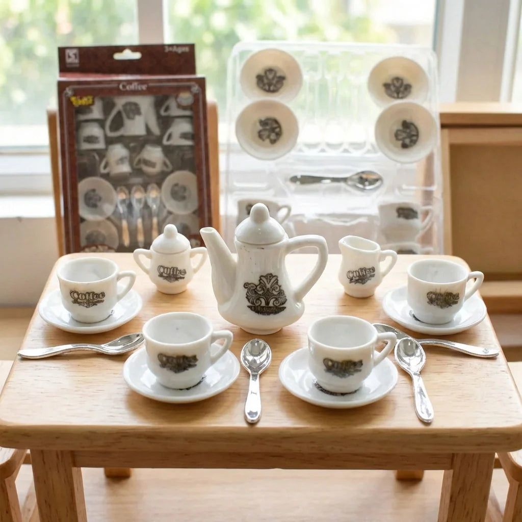Toy tea and coffee set with white teapot, cups, saucers, and silver spoons