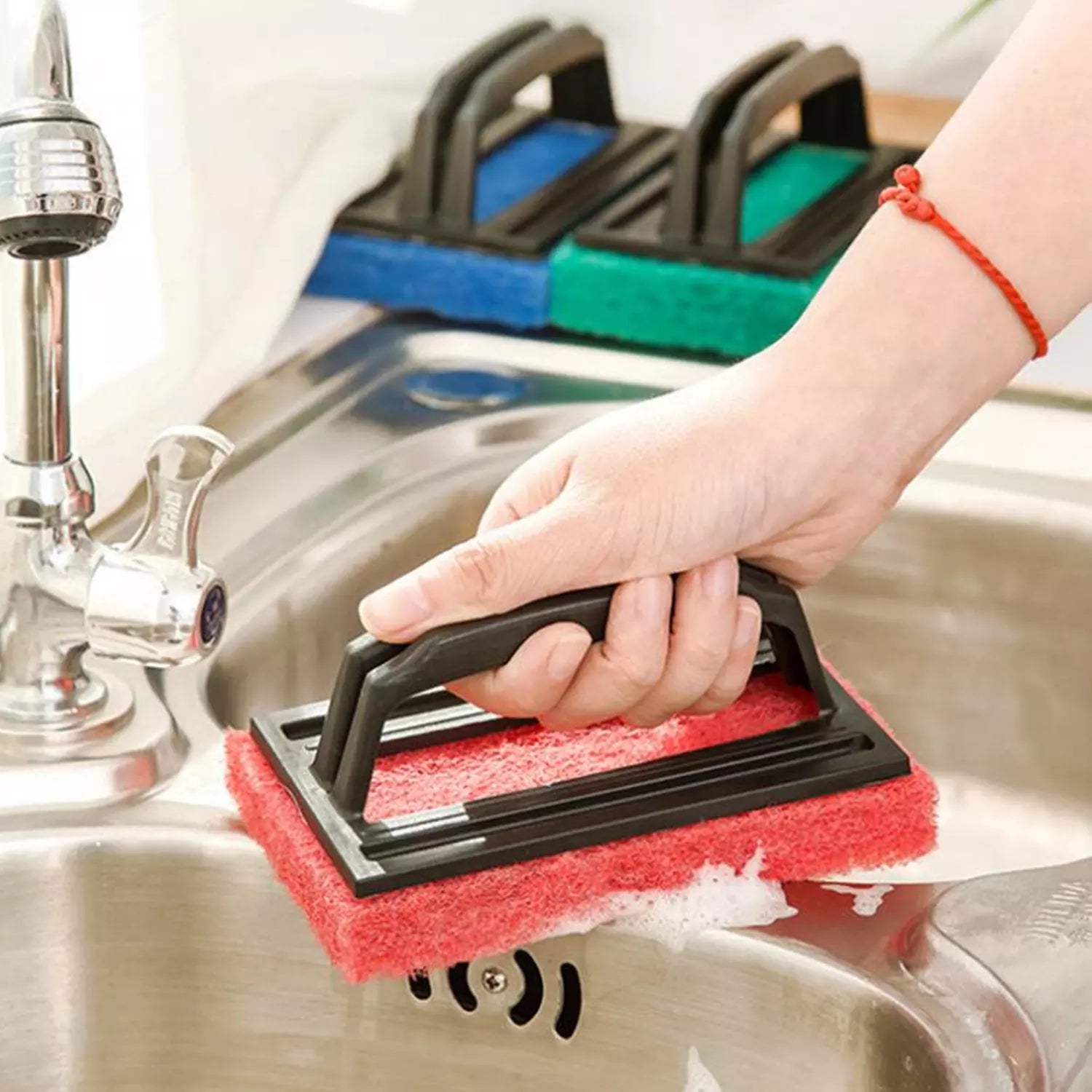 Floor scrubber brush with red scrubbing pad held by hand