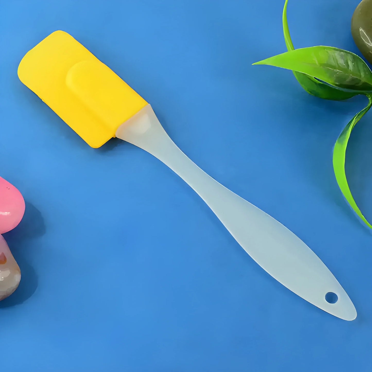 Silicone cooking spatula with yellow handle and white flexible blade, hanging hole