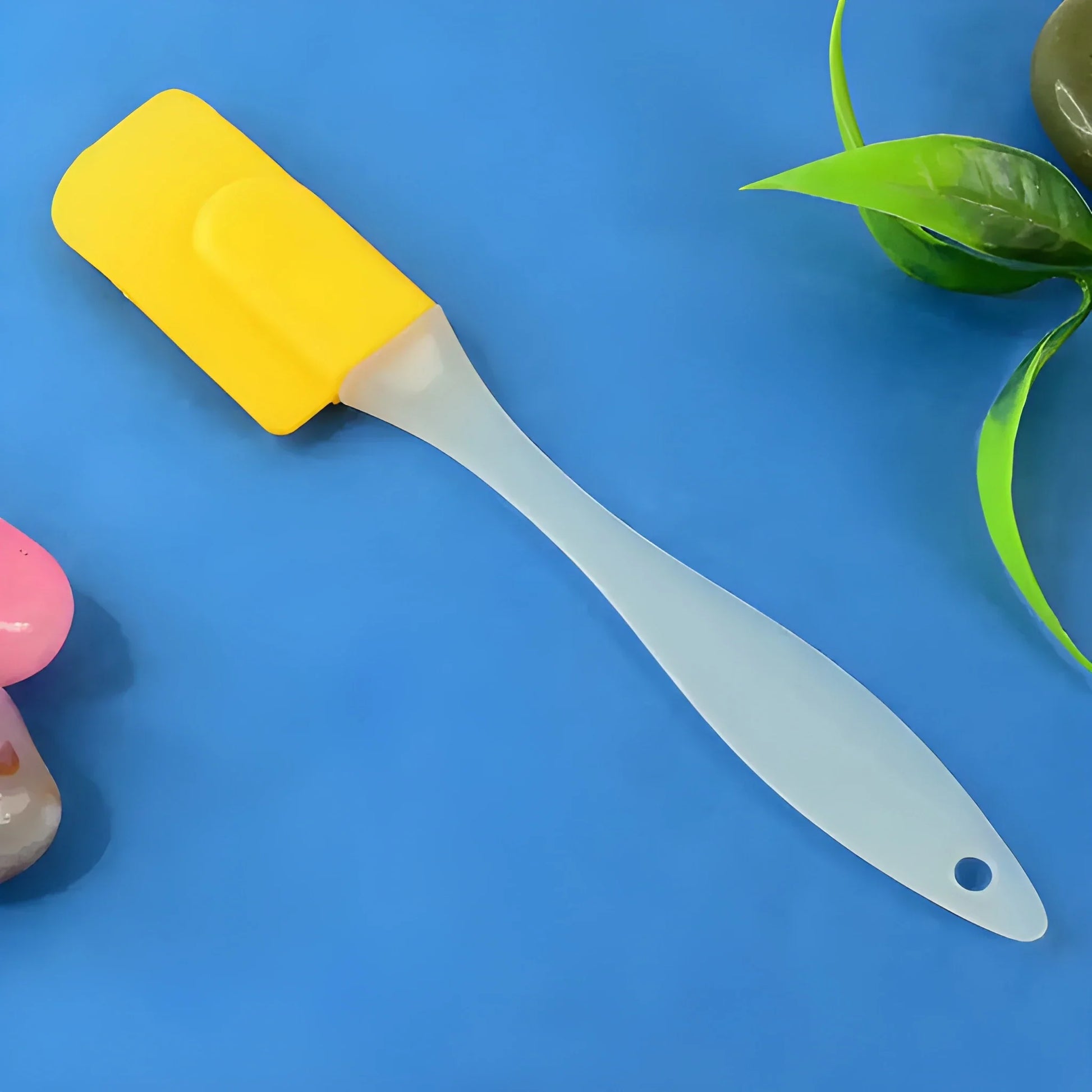 Silicone cooking spatula with yellow handle and white flexible blade, hanging hole