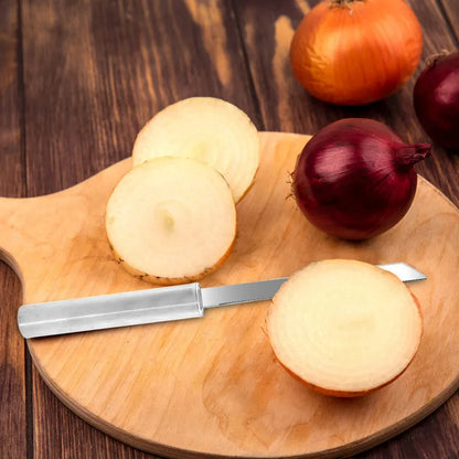 Utility knife with shiny metal blade cutting onion on wooden board