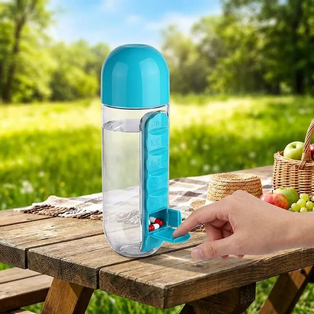 Teal and clear 600 ml water bottle with pill dispenser button on wooden table