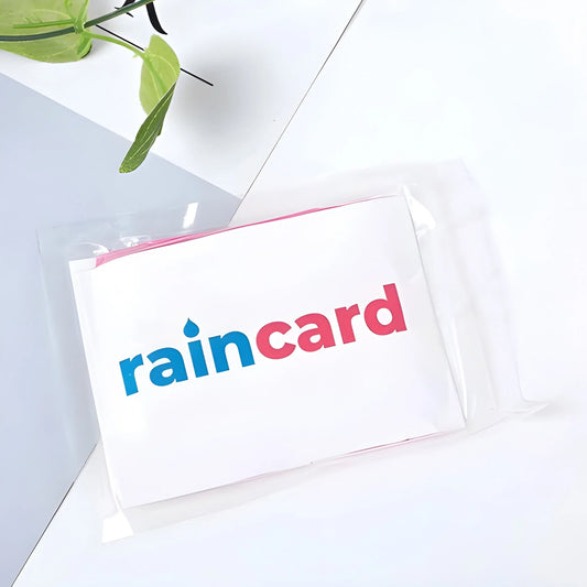 Wallet-sized emergency raincoat pouch, white with red trim and Raincard logo